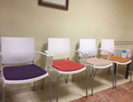 Sala de espera con sillas Atenea con patas y estructura blanca y asiento tapizadas en símil piel de diferentes colores