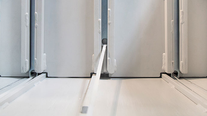 La plancha de prensado avanza en horizontal y comprime el material contra una contraplaca