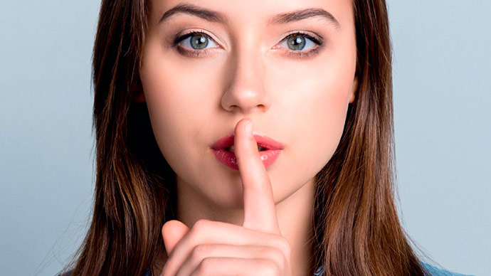 Chica con dedo sobre los labios en señal de reclamar silencio
