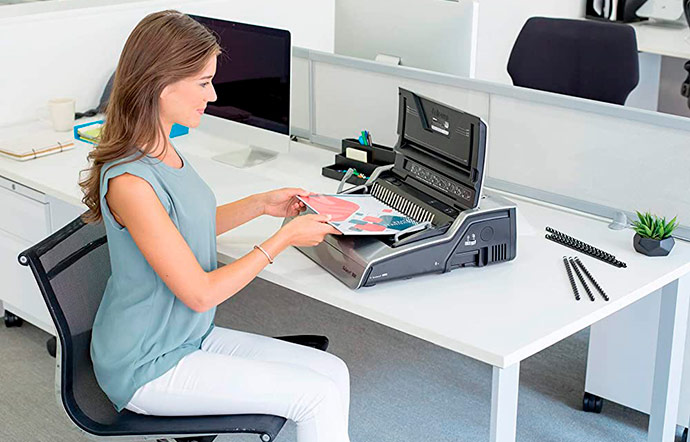Mujer encuadernando documentos en oficina