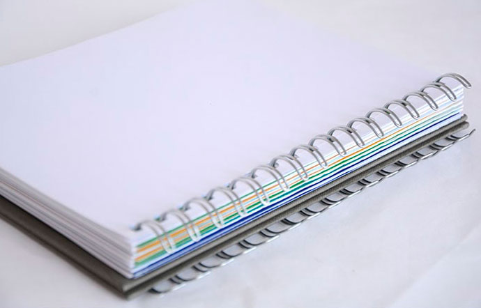 Libreta en DIN-A5 con wire-O plata insertado a falta de ser cerrada