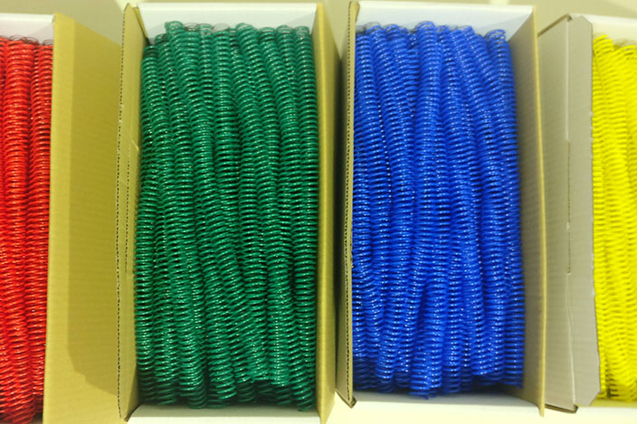 Caja de Asturalba con espirales de plástico rojo, verde, azul y amarillo