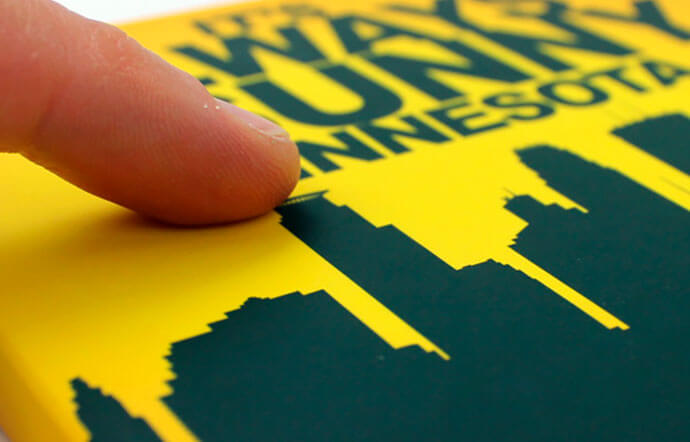 Dedo acariciando la portada de un libro plastificado con Soft Touch