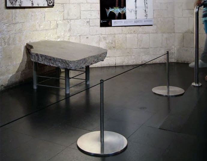 Poste separador bajo separando una piedra de una exposición histórica con cuerda de goma
