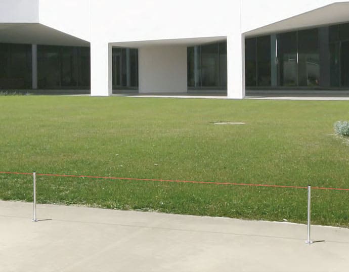 Poste separador bajo separando una piedra de una exposición histórica con cuerda de goma