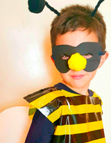 Niño disfrazado de abeja con bolsa de plástico, como las de basura, pero estampada