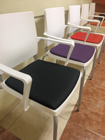 Sala de espera con sillas Atenea con patas y estructura blanca y asiento tapizadas en símil piel de diferentes colores