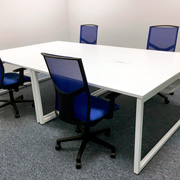 Oficina con sillas Atika de Dile Office con malla ergonómica naranja y asiento azul intenso