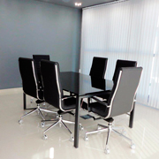 Sala de reunión con sillas Trinity de Dile Office y mesa de cristal en negro
