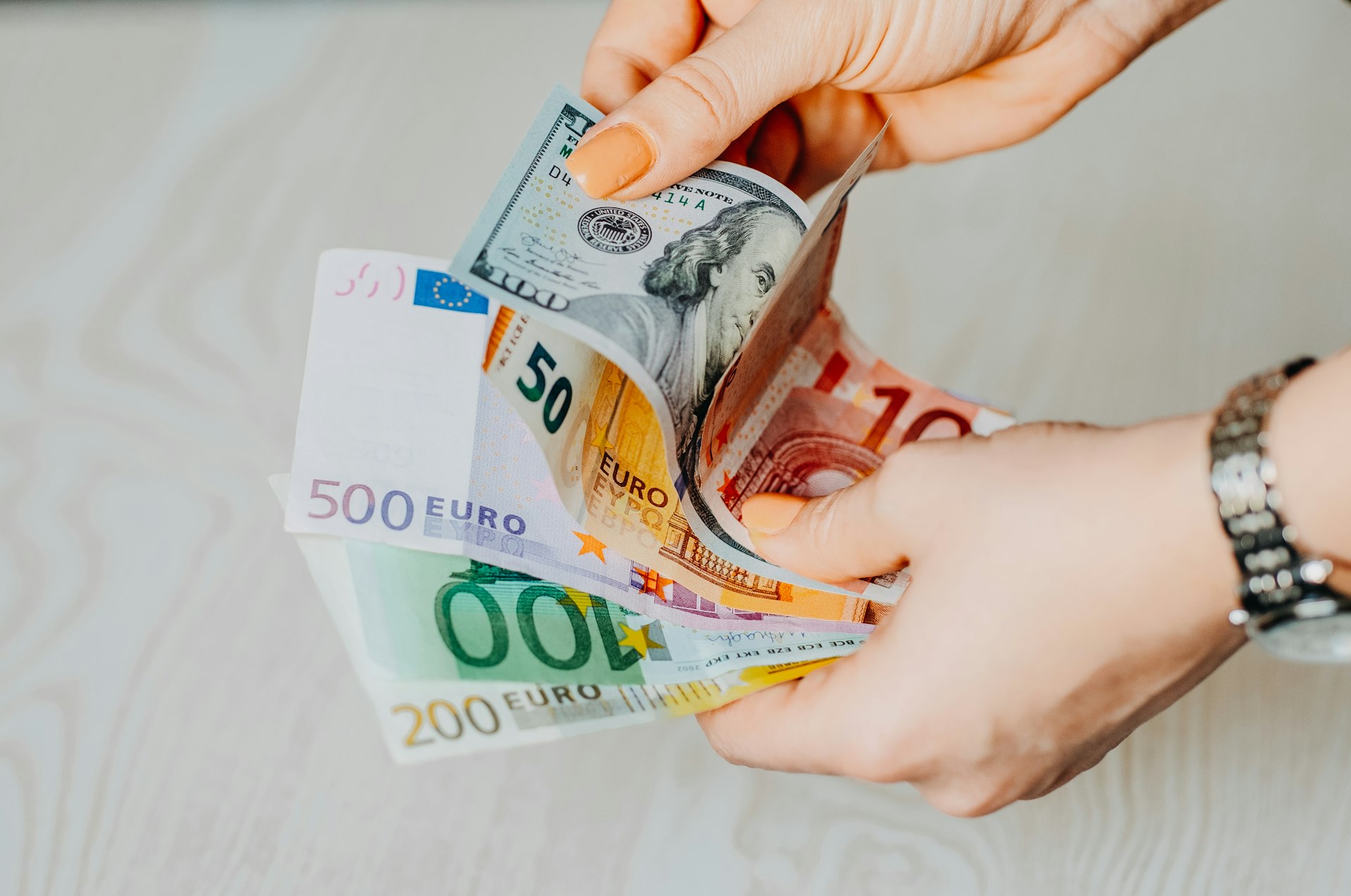 Contar billetes a mano no es práctico para un negocio person holding 100 euro bill