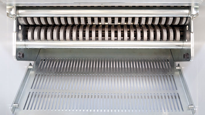 Rascador Un mecanismo rascador diseñado para retirar con eficacia las botellas de plástico o las latas comprimidas de los rodillos del Crusher