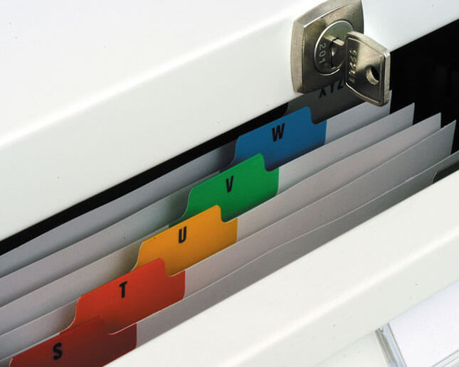 Cajón abierto con fichas ordenadas alfabéticamente y cerradura con llave