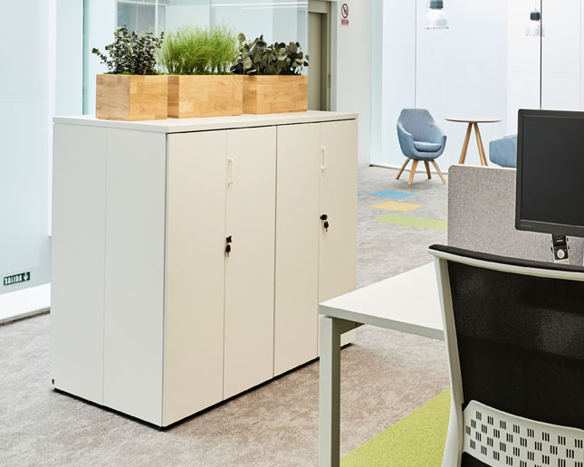 Armarios blancos junto a mesa de oficina Vital Pro y silla Stay de Actiu