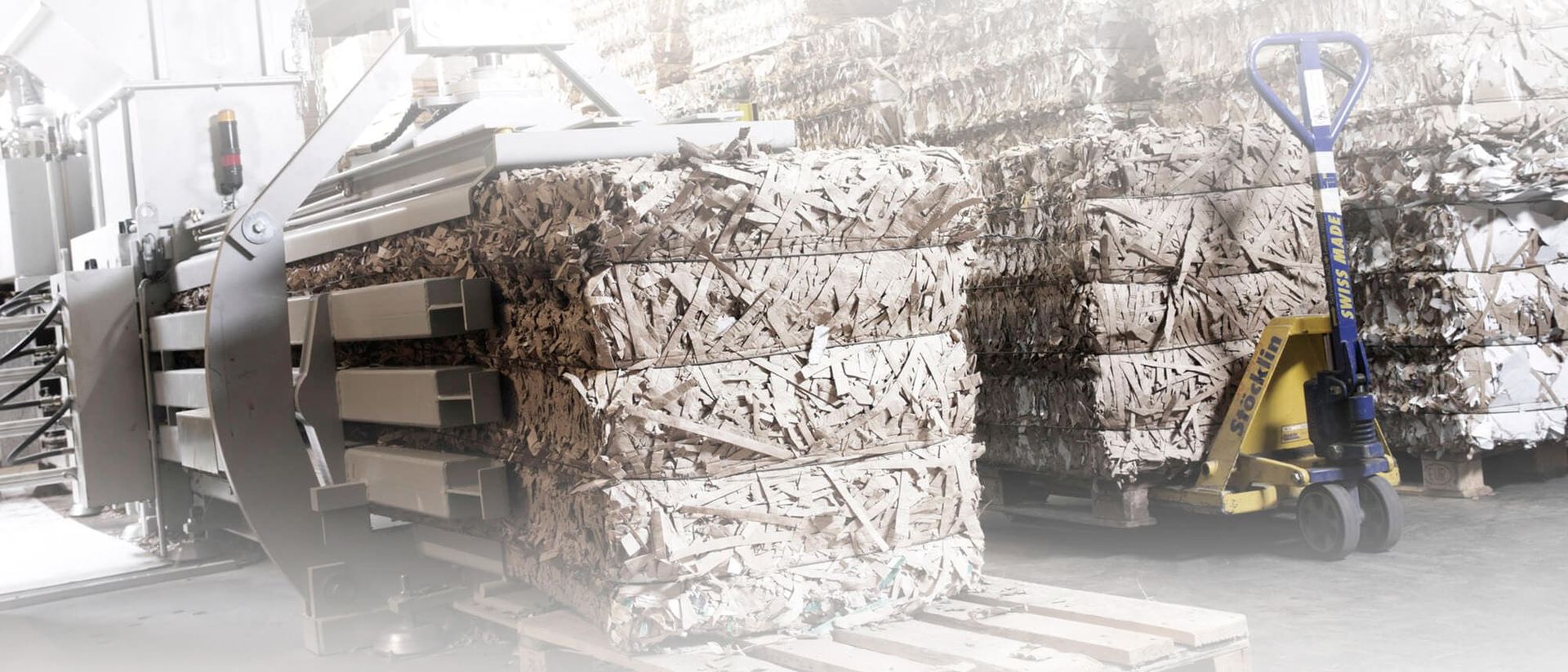 Prensa compactadora horizontal prensando cartón de embalaje en fardos para reducir su volumen y coste de transporte