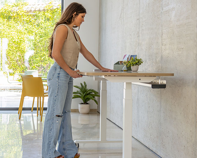 Mujer de pie en mesa Actiu Mobility Step Electra con tablero desplazable para electrificación y cableado oculto