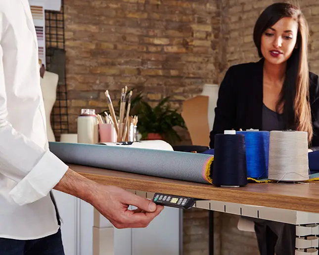 Hombre utilizando el mando para ajustar la altura de la mesa Mobility