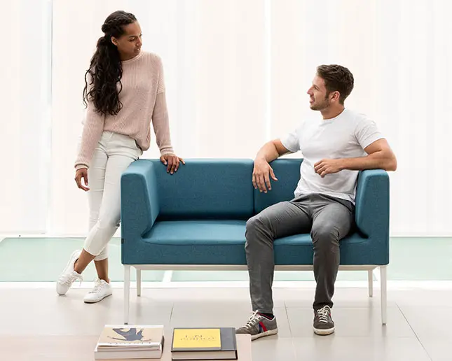 Sofá Longo Actiu de dos plazas tapizado en azul con estructura blanca en oficina colaborativa