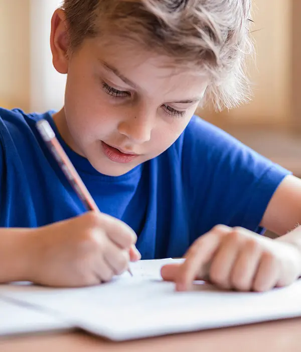 Niño escribiendo en cuadernos