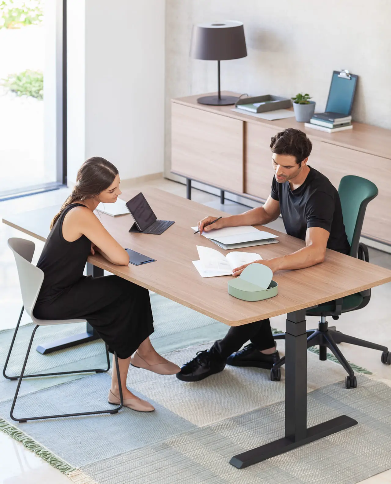 Hombre y mujer tratando temas laborales sobre mesa de oficina