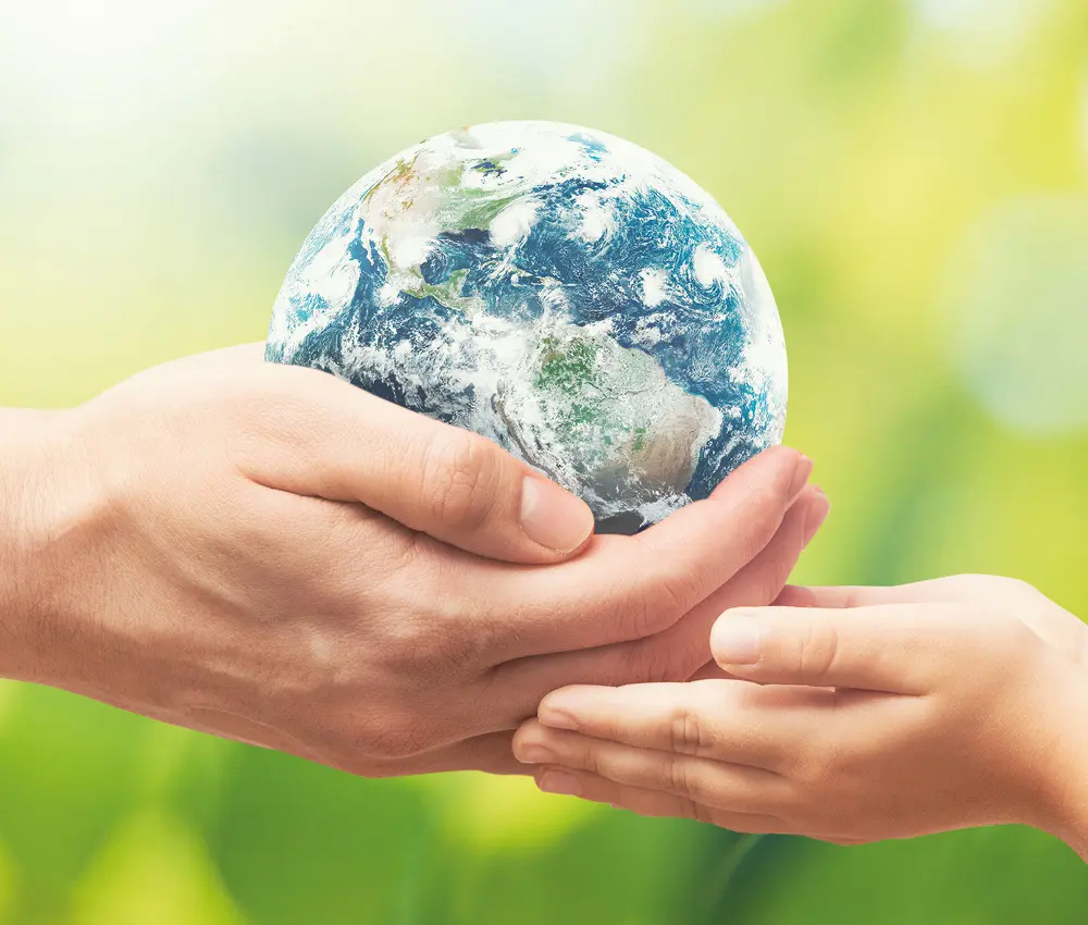 Manos sosteniendo un planeta como símbolo del compromiso ambiental de HSM