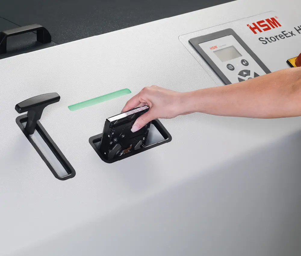 Mano introduciendo un disco duro en la abertura de la HSM HDS 150