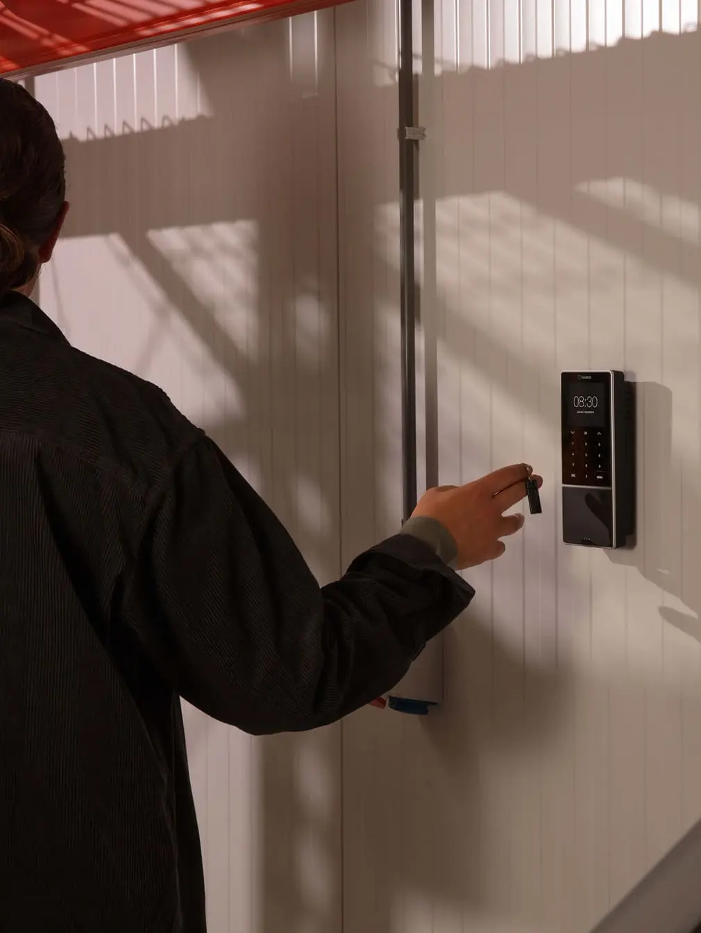 Trabajador fichando al llegar al trabajo con su llavero