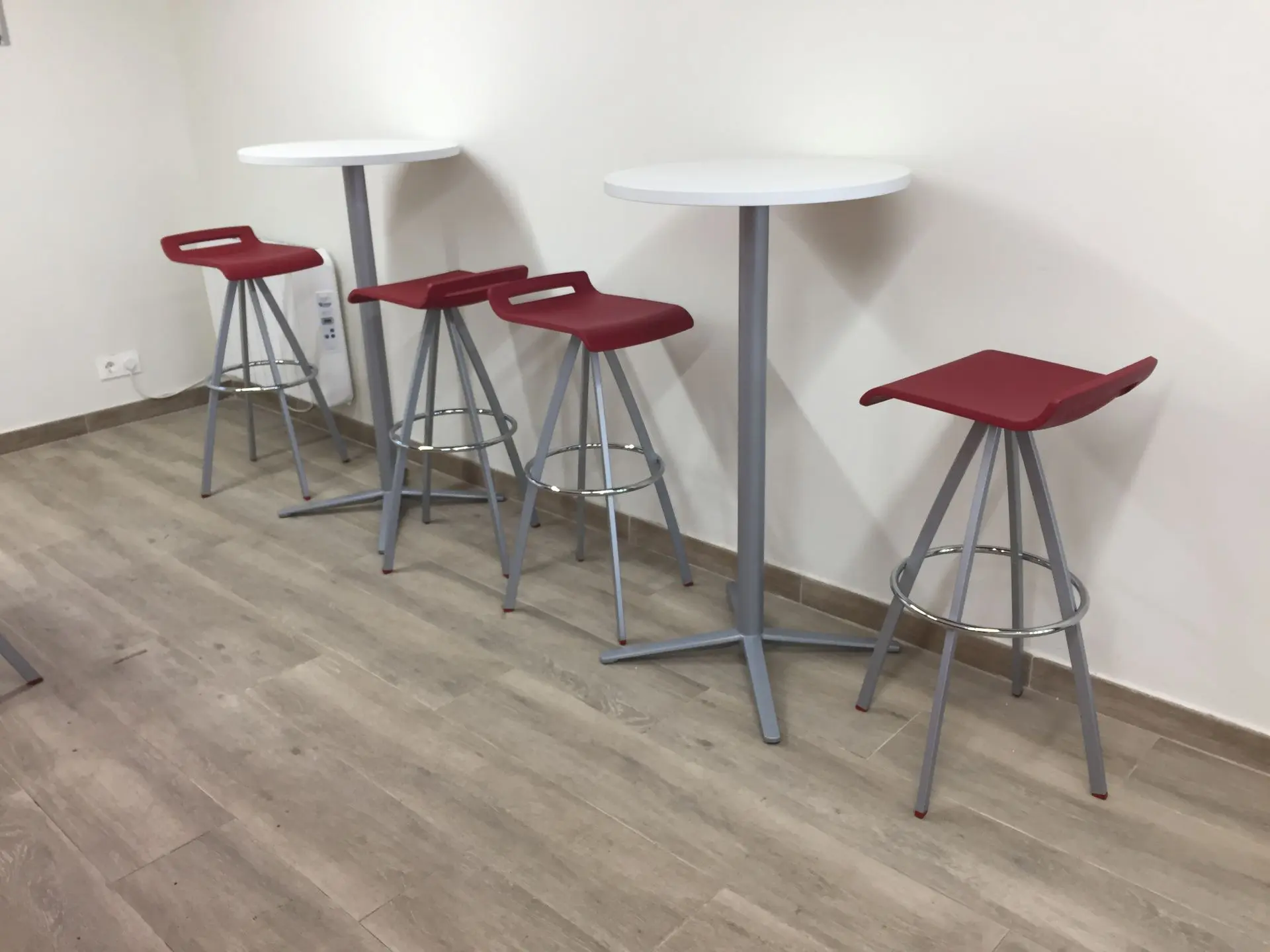 Zona de descanso con taburetes y mesas altas Zona de descanso con taburetes y mesas altas