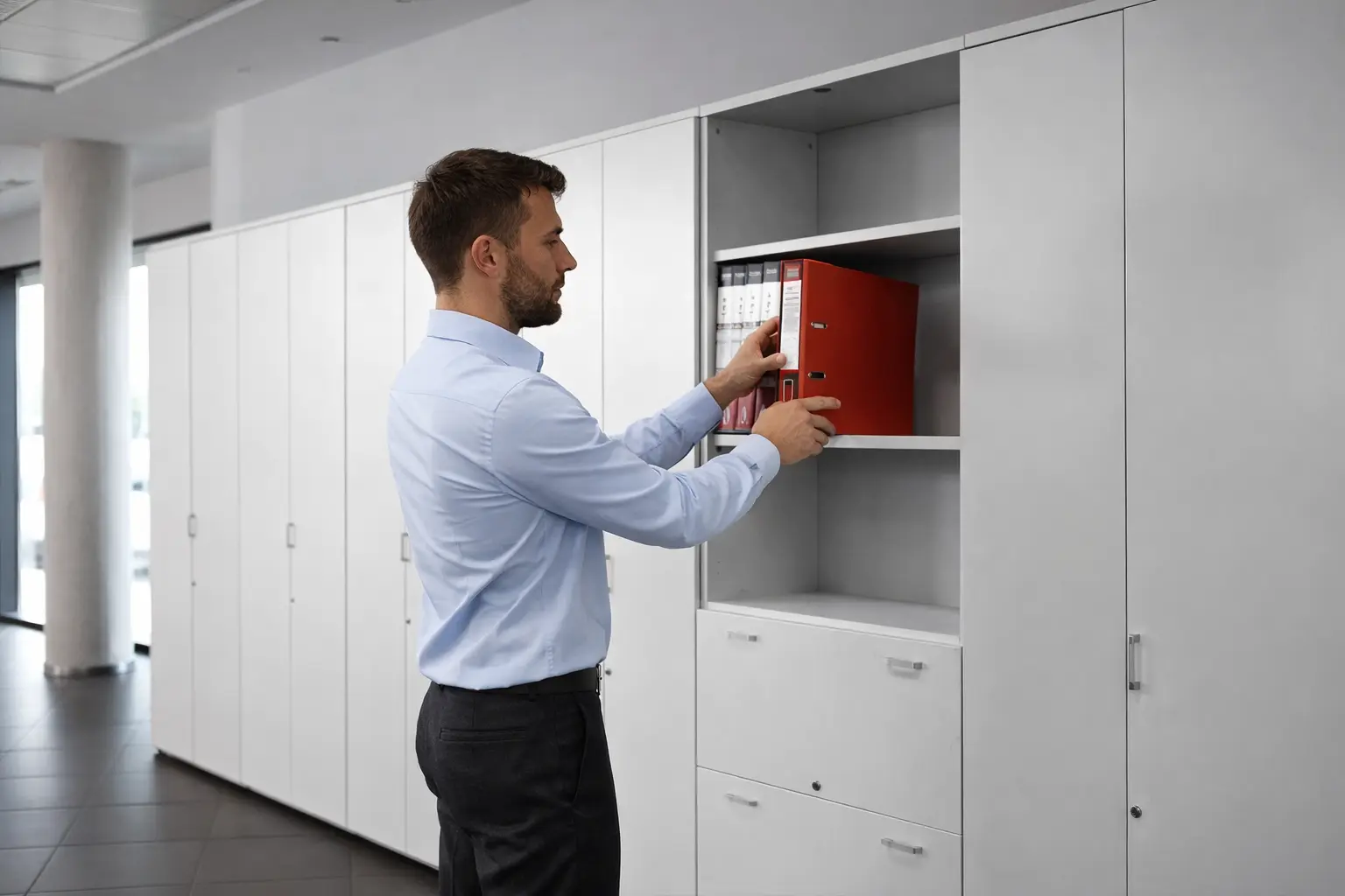 Hombre guardando archivador de armario