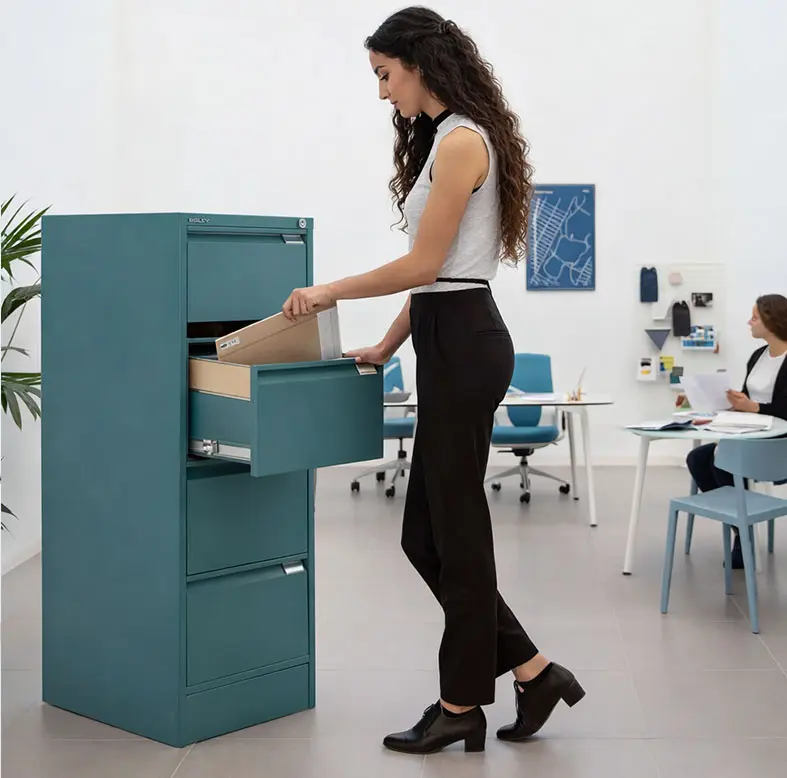 Chica guardando carpeta en archivador metálico para carpetas colgantes en oficina de diseño