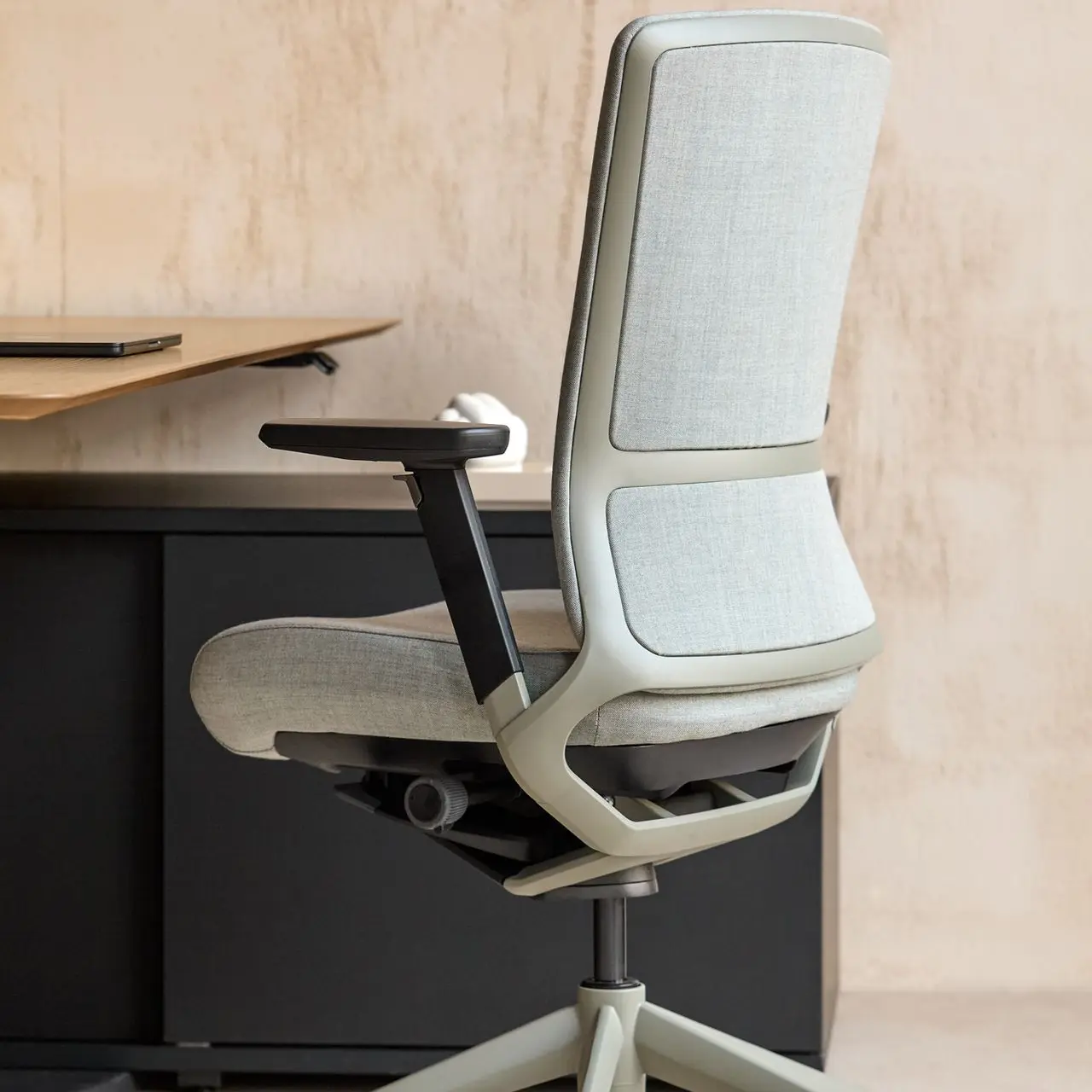 Respaldo tapizado en gris claro sobre estructura de titanio