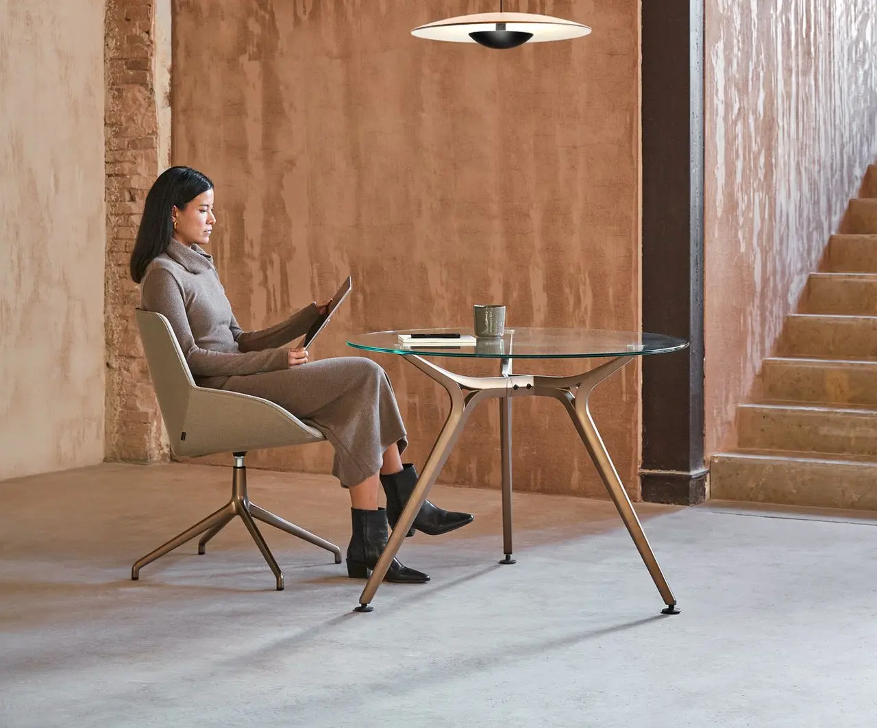 Mesa Arkitek de cristal con estructura en acabado Titanio en zona de relax para trabajar con iPad