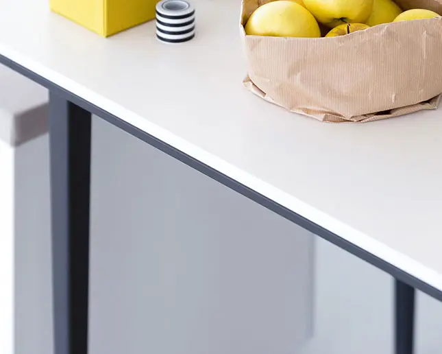 Detalle superficie melamina mesa Longo Actiu con manzanas