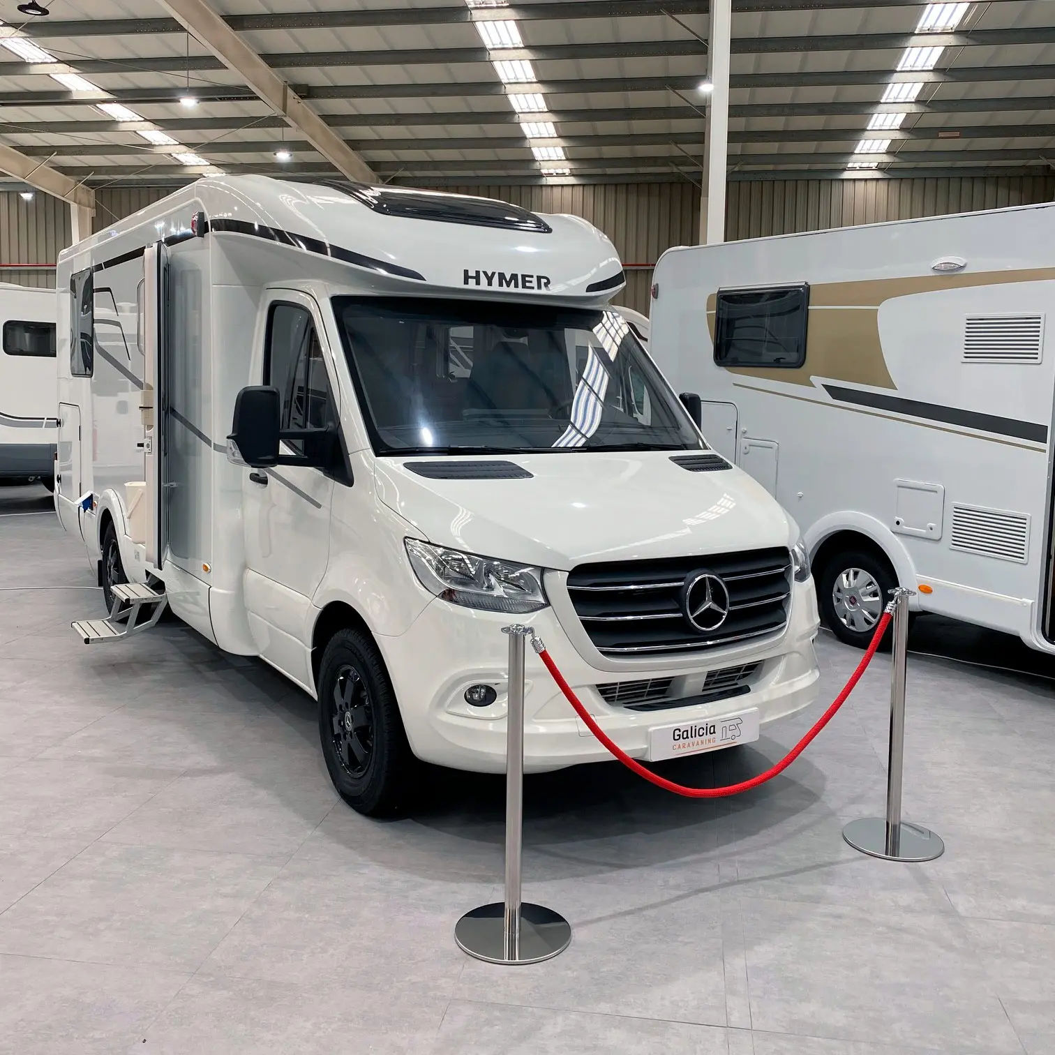 postes separadores con cordón rojo delimitando una autocaravana Hymer en exposición profesional.