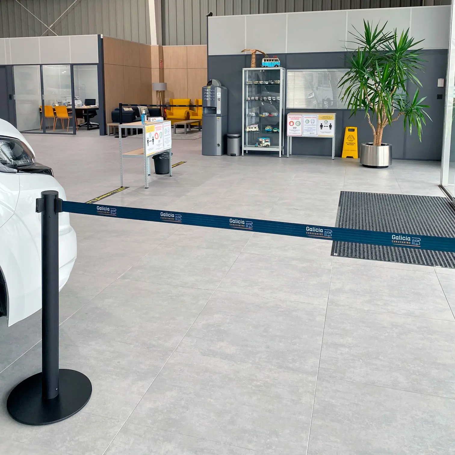 poste separador negro con cinta extensible personalizada instalado en exposición de caravanas.