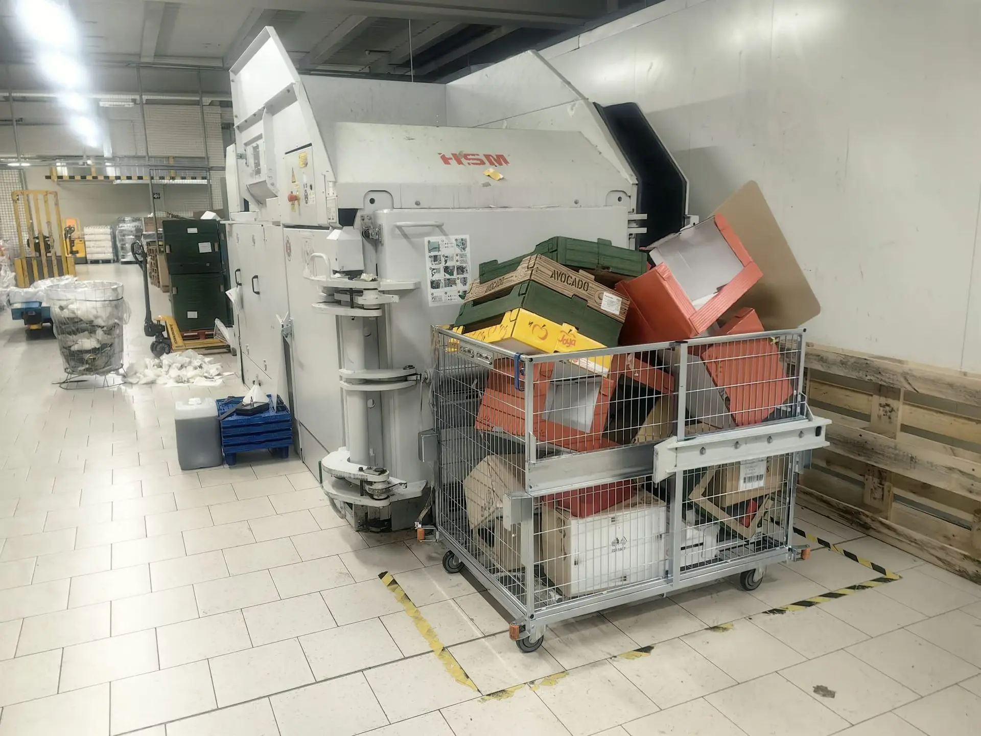 Prensa horizontal HSM con volteador de contenedores en instalación real de supermercado