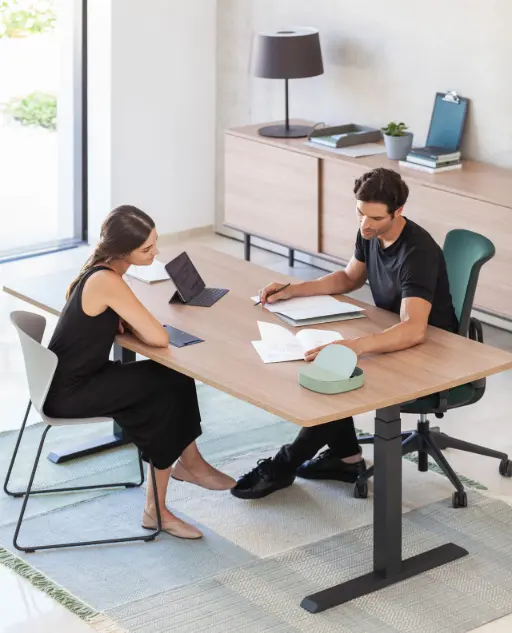 Hombre y mujer tratando temas laborales sobre mesa de oficina