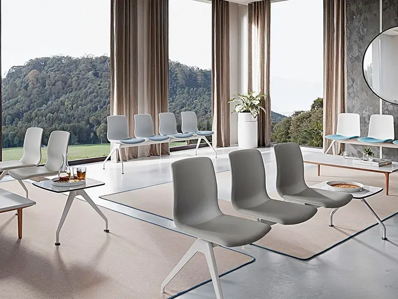 Bancadas Noom 50 Actiu en gris y blanco con pad azul en sala de espera con ventanales