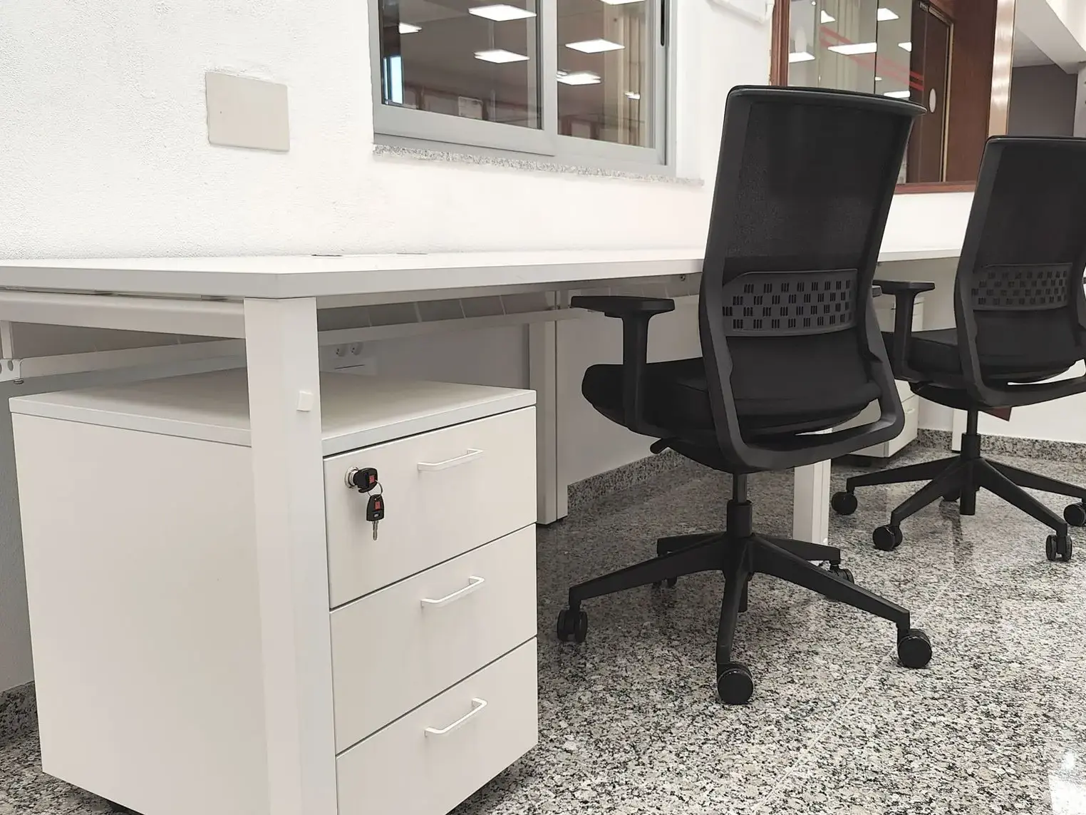 Taquilla instalada en la entrada de un edificio público o zona de control de acceso, ambiente institucional neutro. Alt: Taquilla para móviles en la entrada de un edificio de administración pública