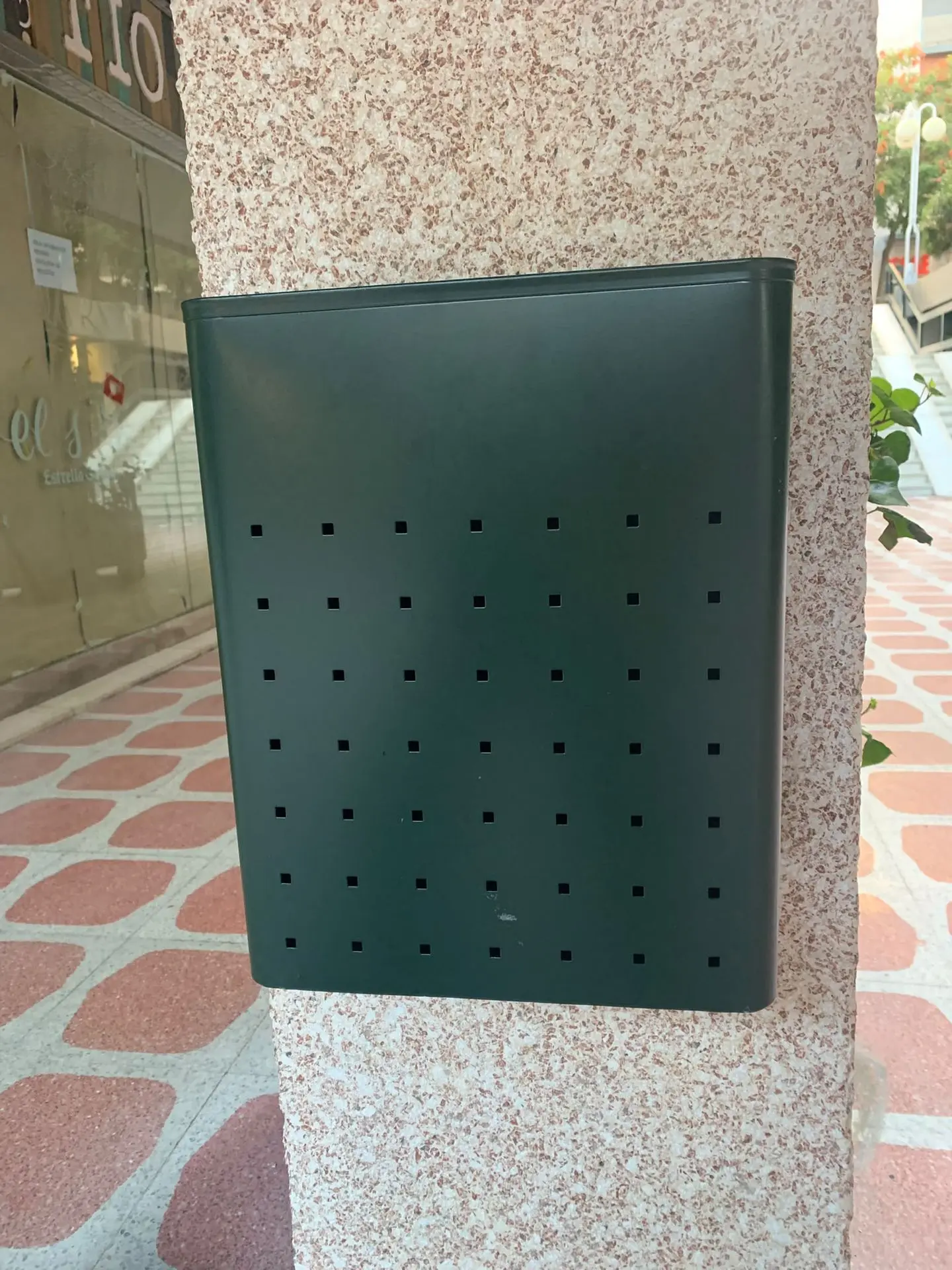 Las papeleras se anclan a los pilares del edificio Papelera verde anclada a pilar del edificio