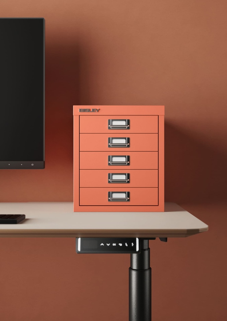 Cajonera color coral con cinco cajones sobre mesa de oficina elevable