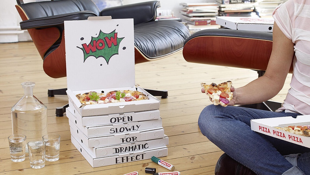 Mano sacando un marcador rojo Edding 500 de un bolsillo con herramientas.