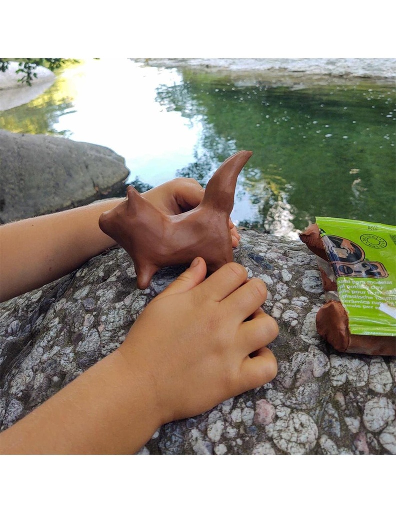 Niño creando una escultura sencilla con arcilla Sio-2 en clase de manualidades al aire libre