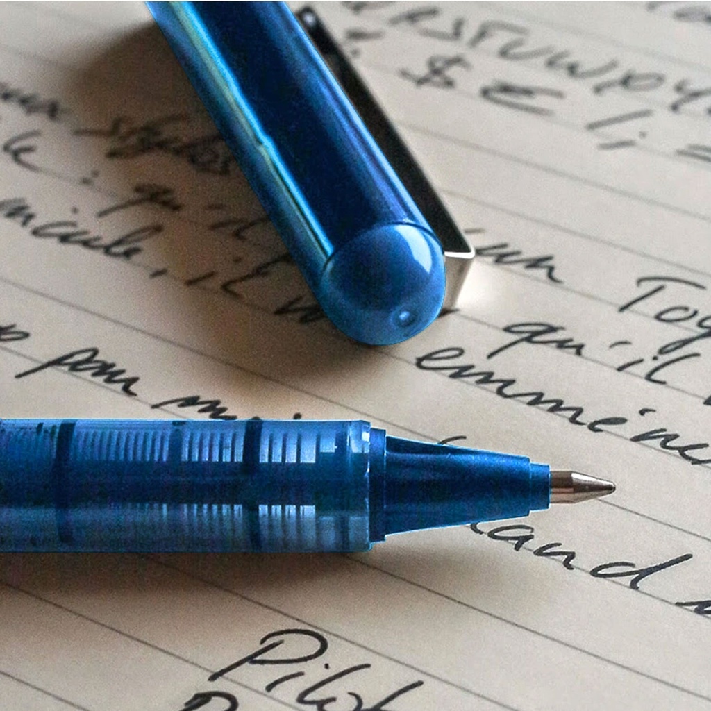 Bolígrafo Pilot V-Ball 0,5 azul escribiendo sobre papel, primer plano del trazo de tinta líquida azul