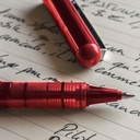 Detalle de la punta extrafina del bolígrafo Pilot V-Ball 0,5 rojo con grip visible y tinta líquida roja