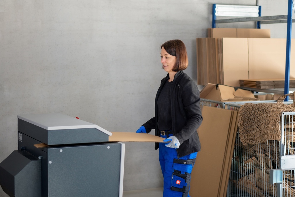 Mujer trabajando con máquina para hacer virutas de cartón HSM ProfiPack ecoChip
