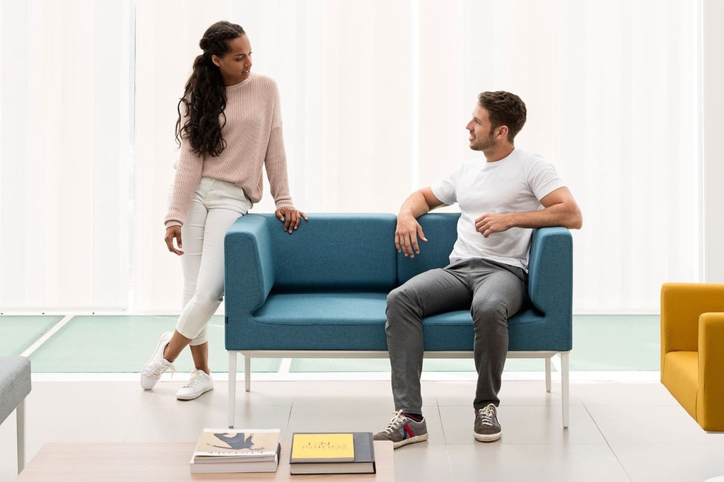 Hombre y mujer charlando en sofá Longo Nómada Express