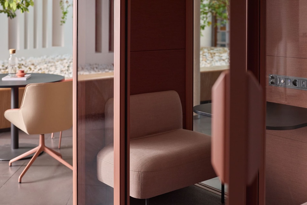 Cabina acústica rosa Qyos de Actiu para reuniones con asientos