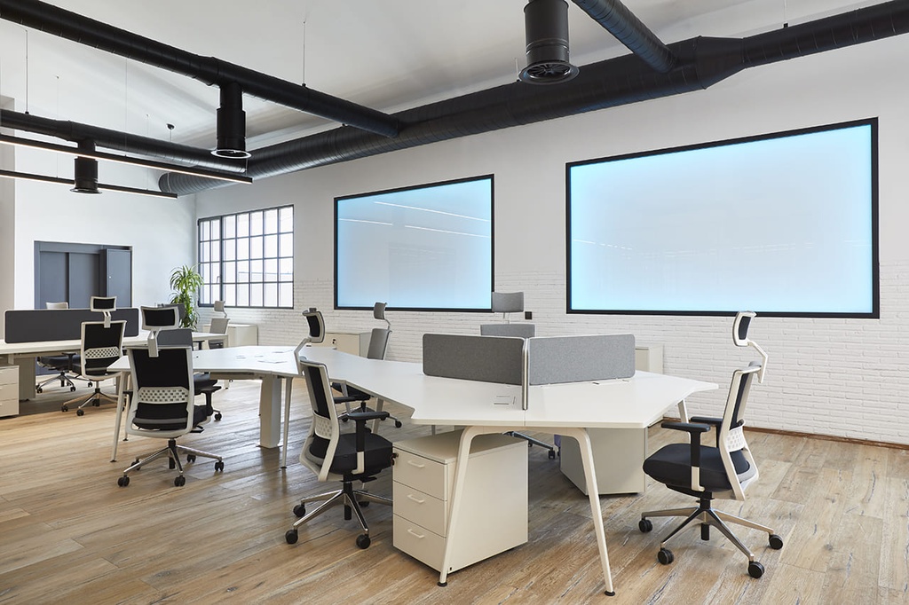 Cajonera blanca de 3 cajones en oficina con mesas Twist y sillas Stay con cabecero