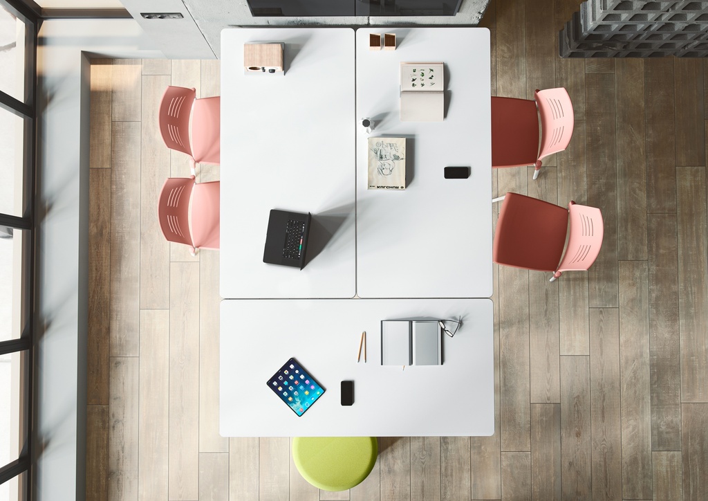Vista cenital de mesas móviles unidas para reunión con sillas Spacio en color rosa coral con patas blancas