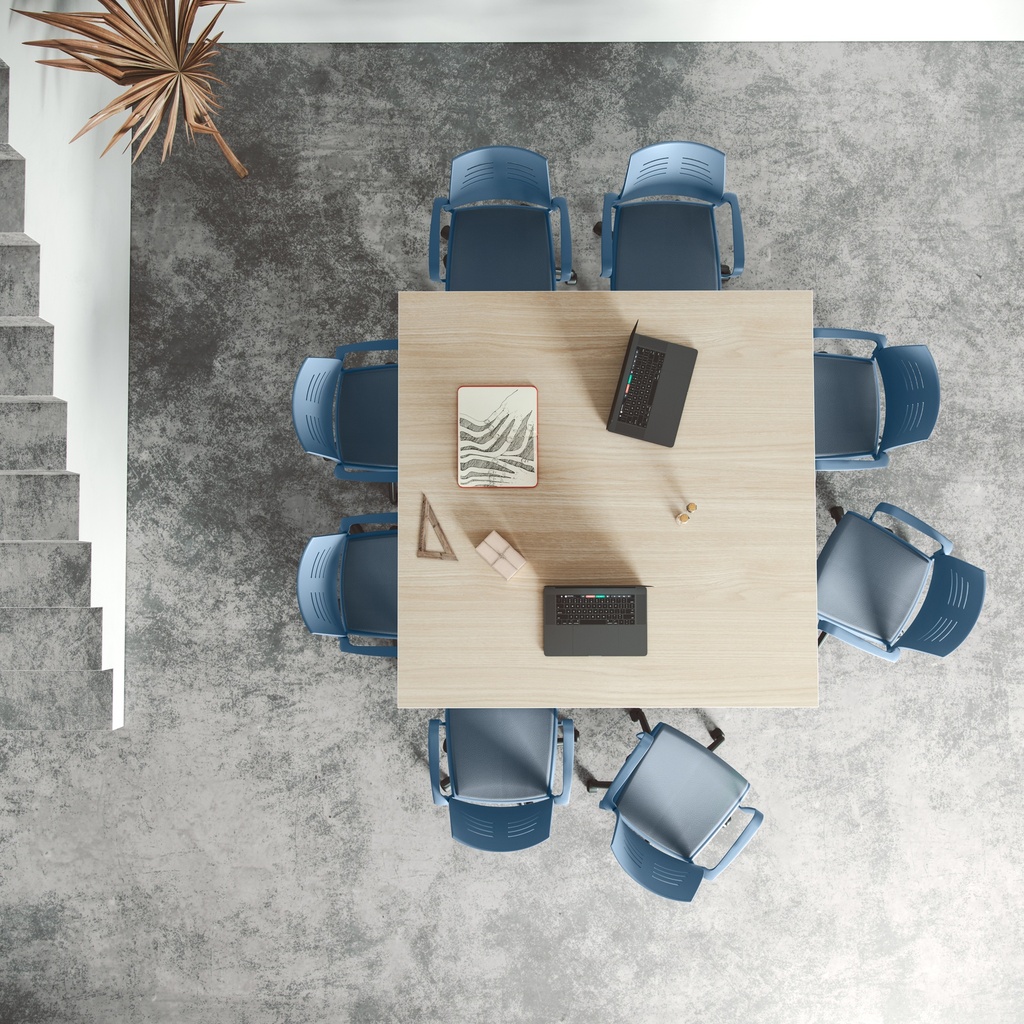 Vista cenital de silla Spacio de Actiu en azul con asiento acolchado y tapizado a juego en mesa de reunión